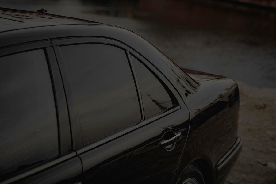 Sisi mobil hitam dengan kaca film gelap